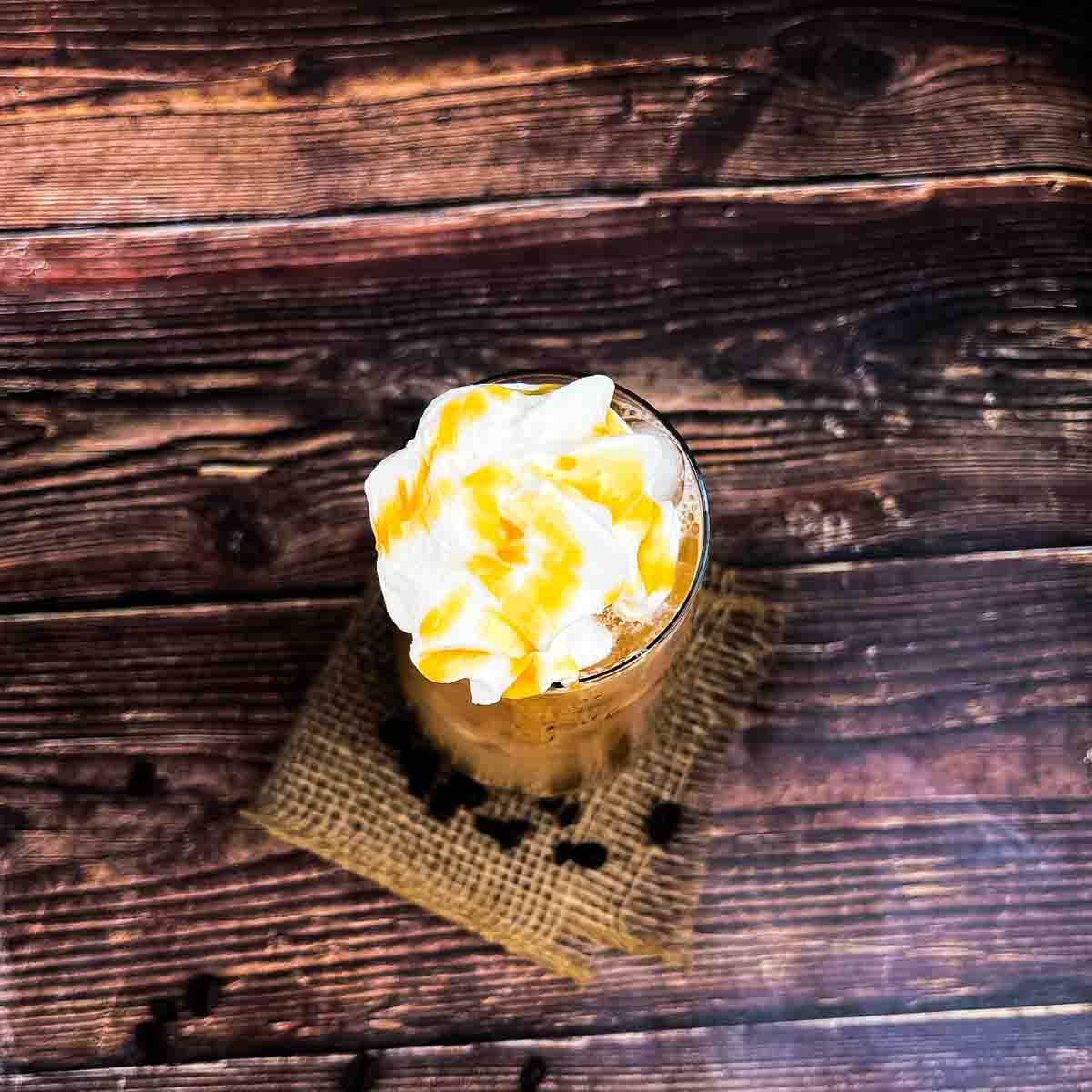 The caramel iced coffee topped with whipped cream and caramel syrup.