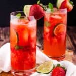 Two glasses of non-alcoholic strawberry mojitos in highball glasses.