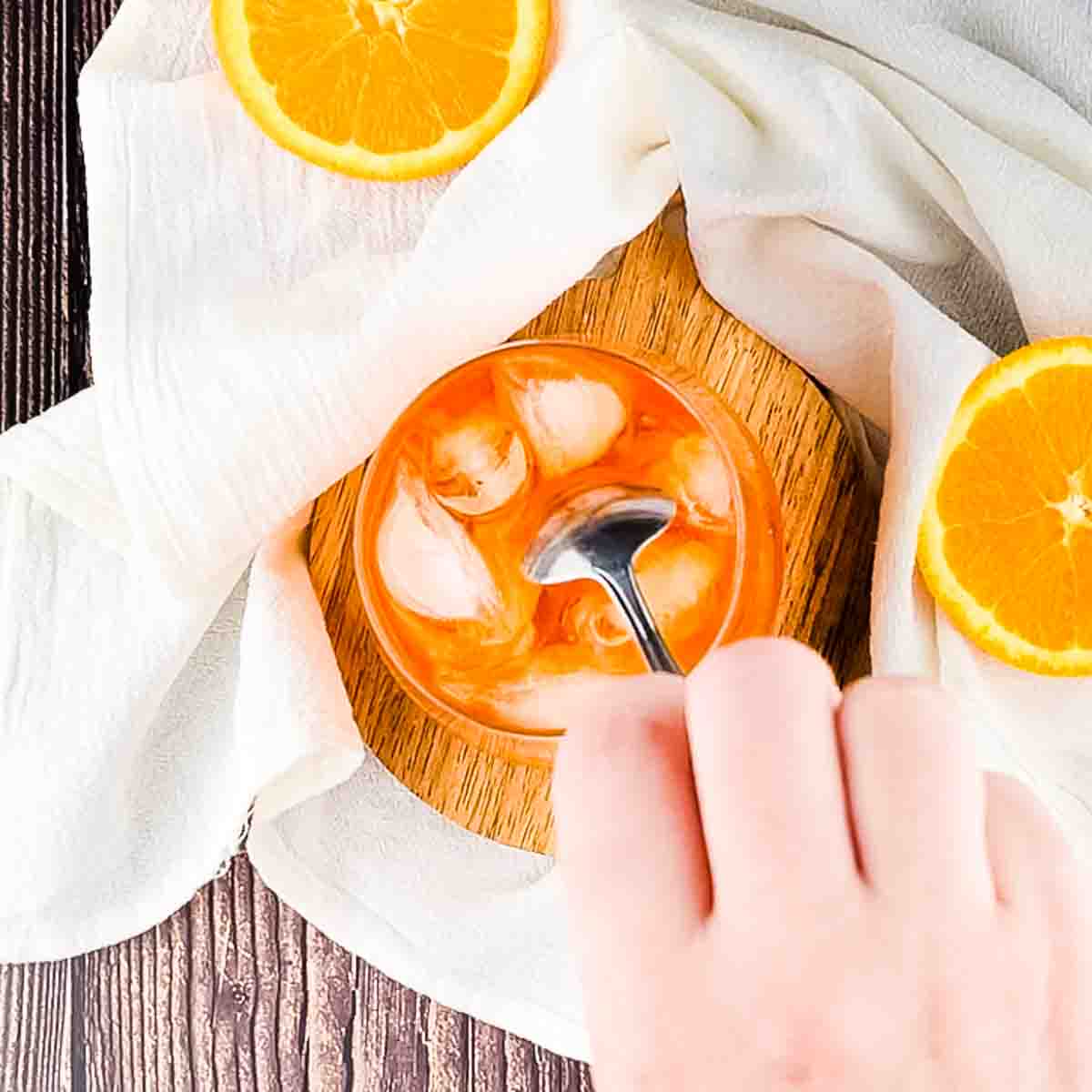 Stirring the finished Aperol spritz with a spoon.