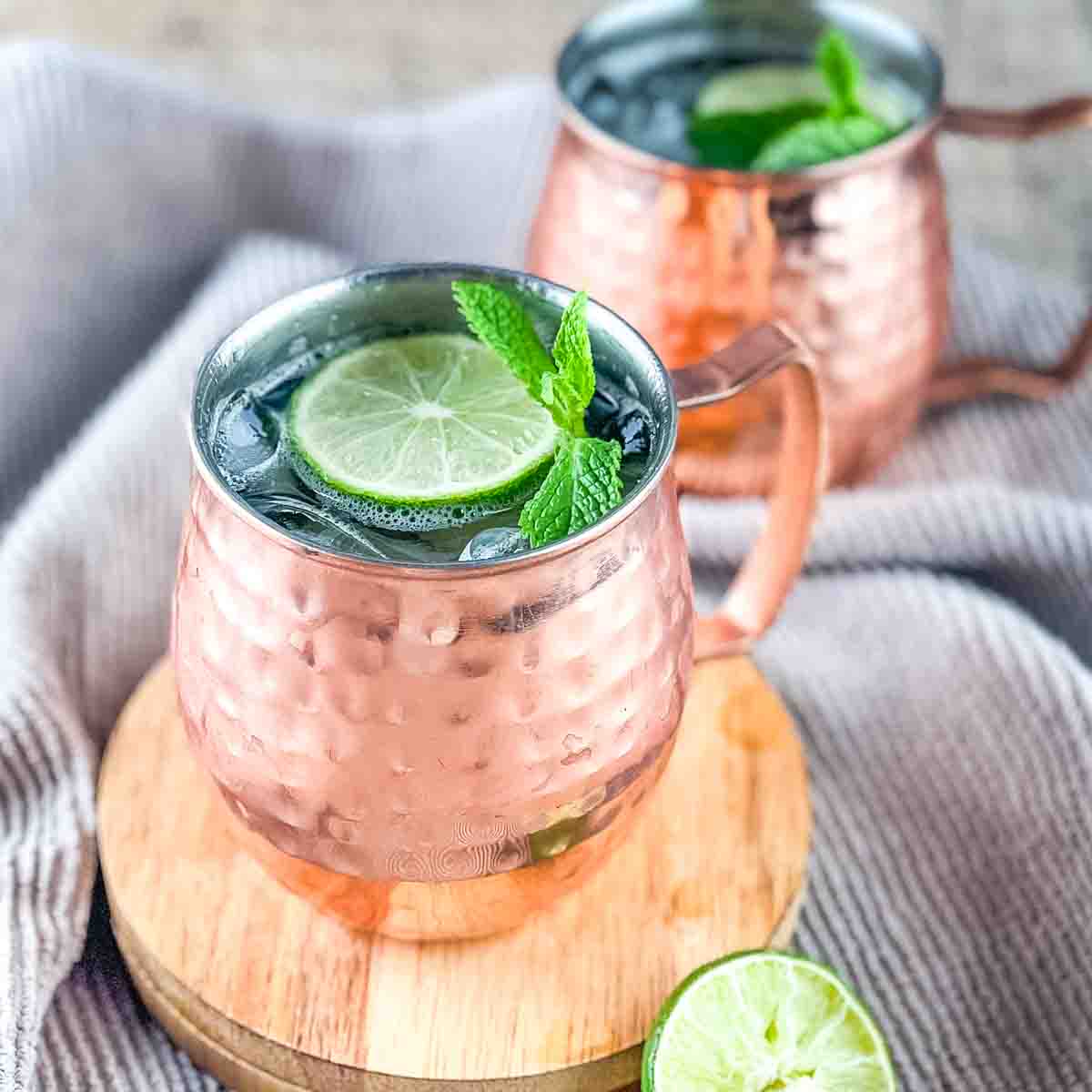 Two copper mugs filled with the Moscow mule made with white rum.