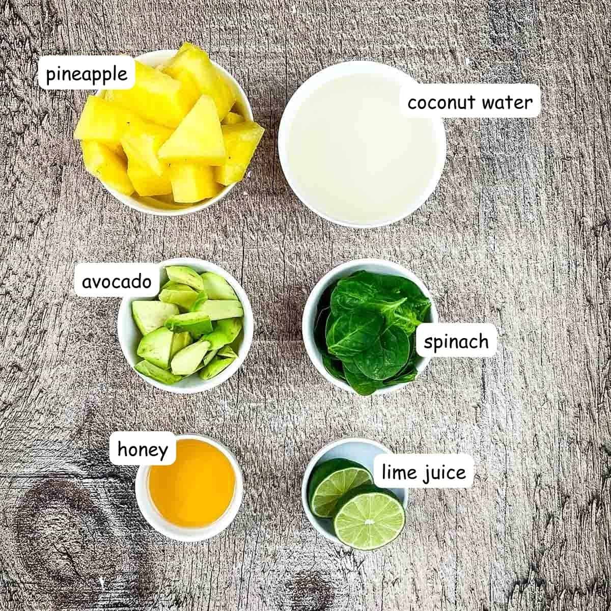 Ingredients for avocolada smoothie in individual bowls on a table.