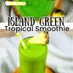 A tall glass filled with an Island Green Tropical smoothie garnished with a pineapple wedge and a yellow and white striped straw.