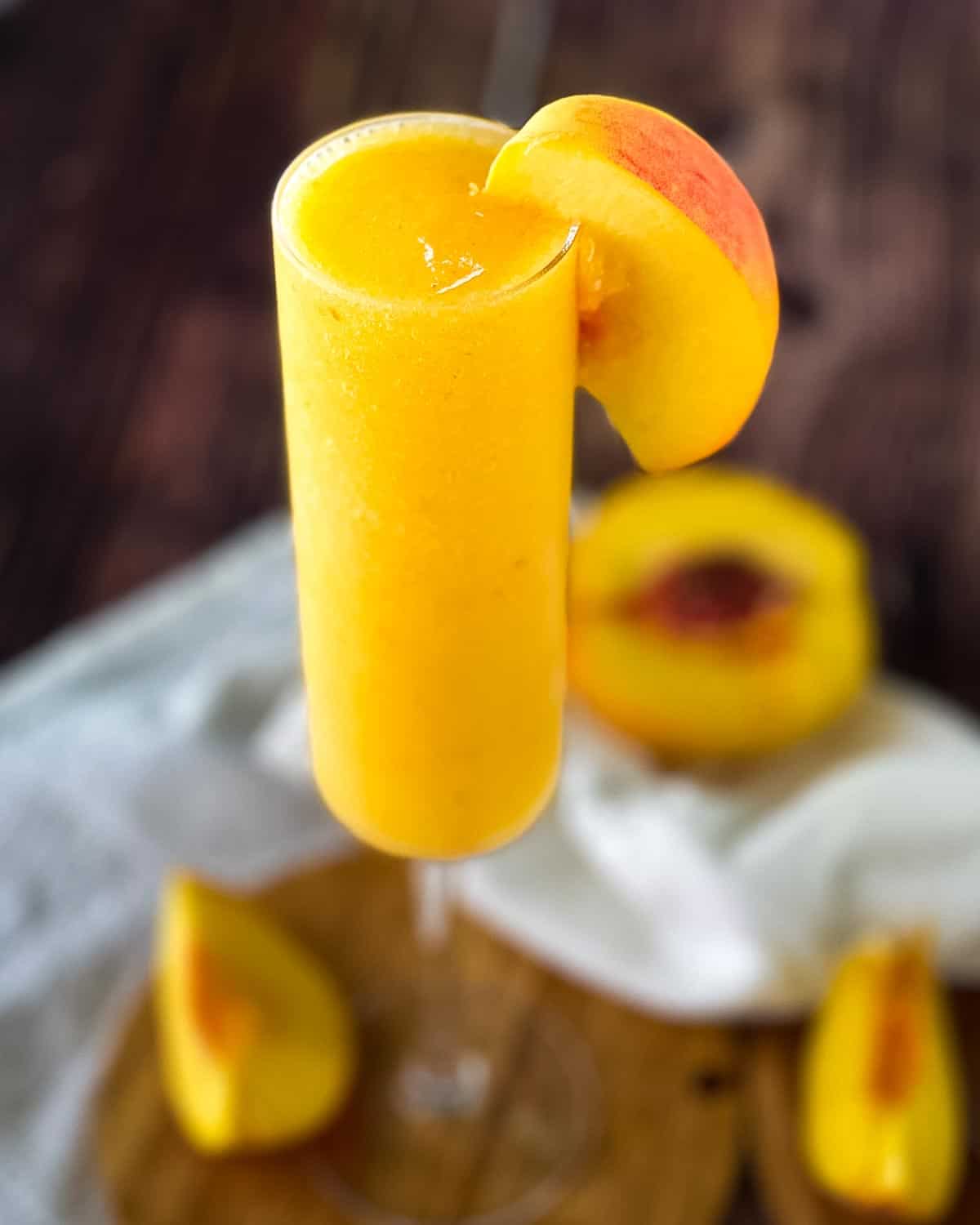 A champagne glass filled with a frozen peach bellini.