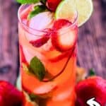 A strawberry mojito cocktail served in a tall glass with fresh mint, lime wedge, crushed ice, and sliced strawberries, styled for summer.