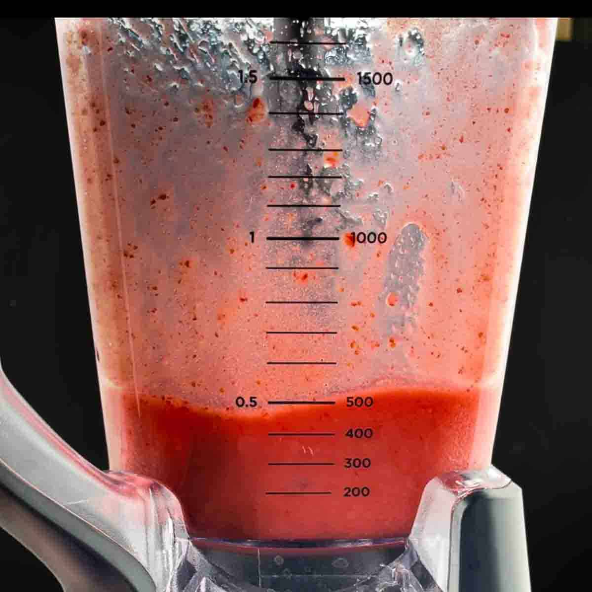 Ingredients for strawberry daiquiri blended in a blender.